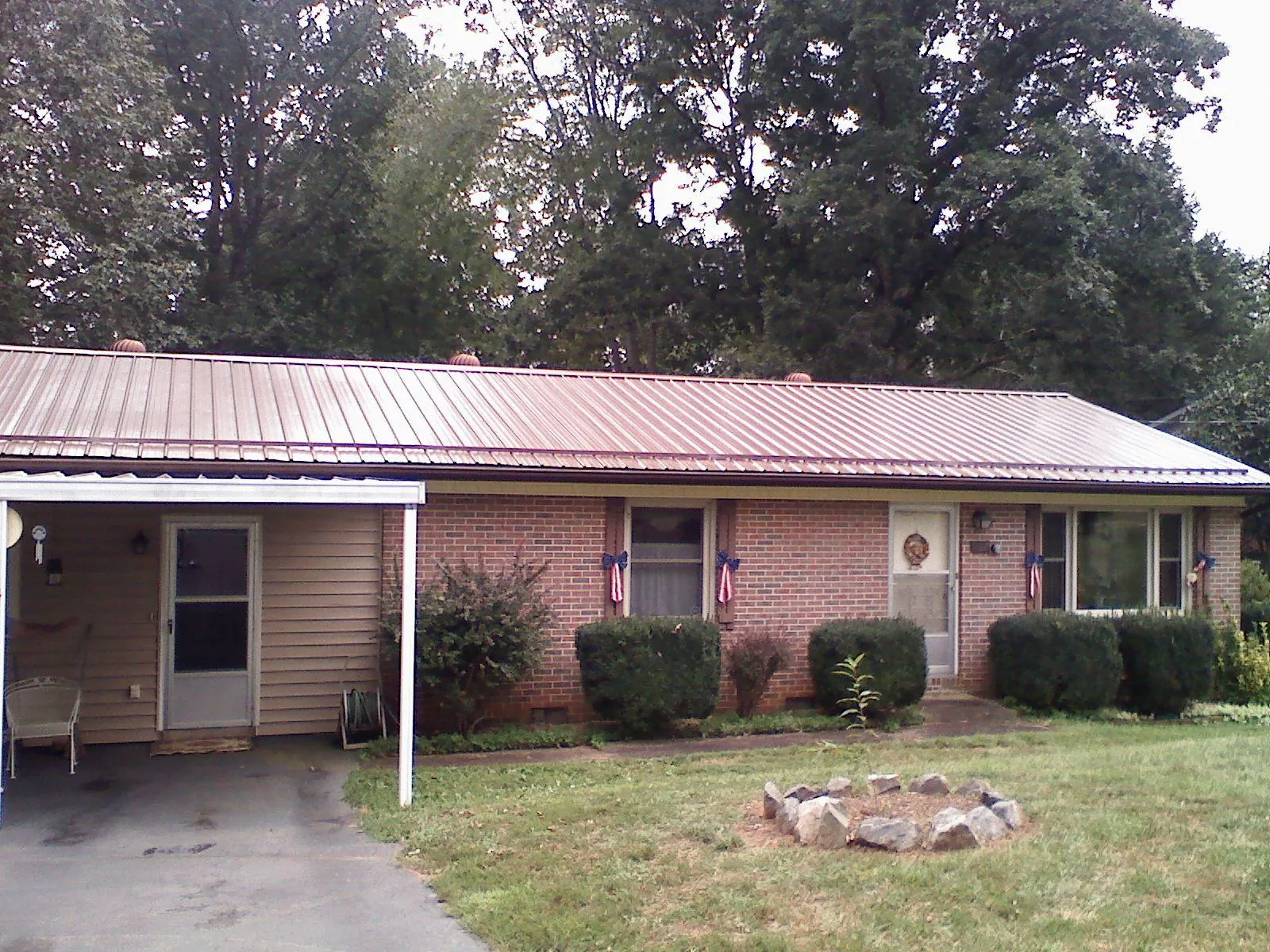Bronze metal roof and carport on a brick ranch home — Roof Repair work by our crew in Perkinsville