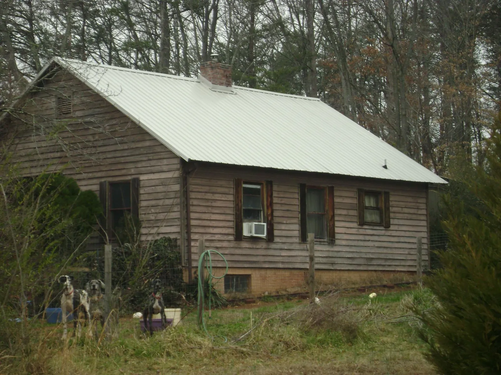 White metal roof on an old wood sided farmhouse, from a Metal Roof Installation job in Perkinsville